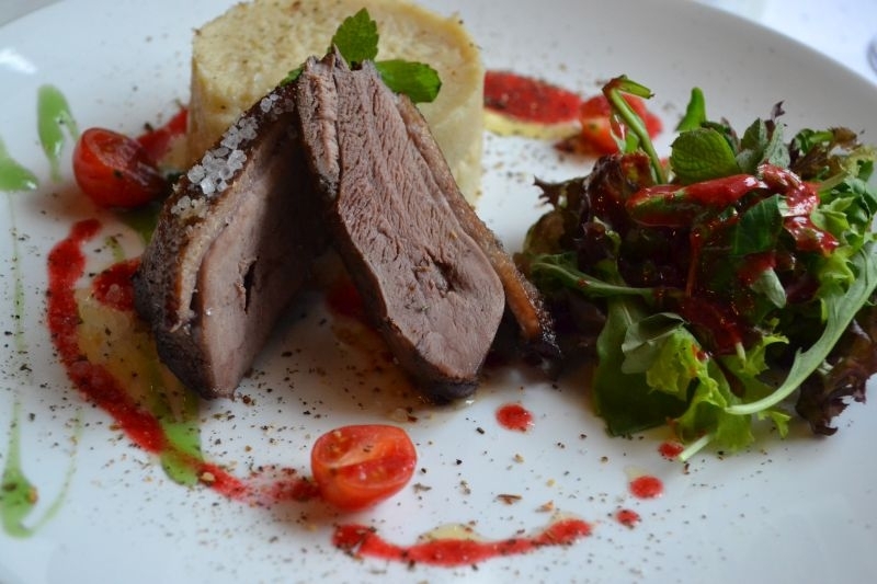 Marynowana pierś gęsia zapiekana w soli morskiej z dodatkiem puree z selera w towarzystwie kruchych sałat z sosen malinowym winegret